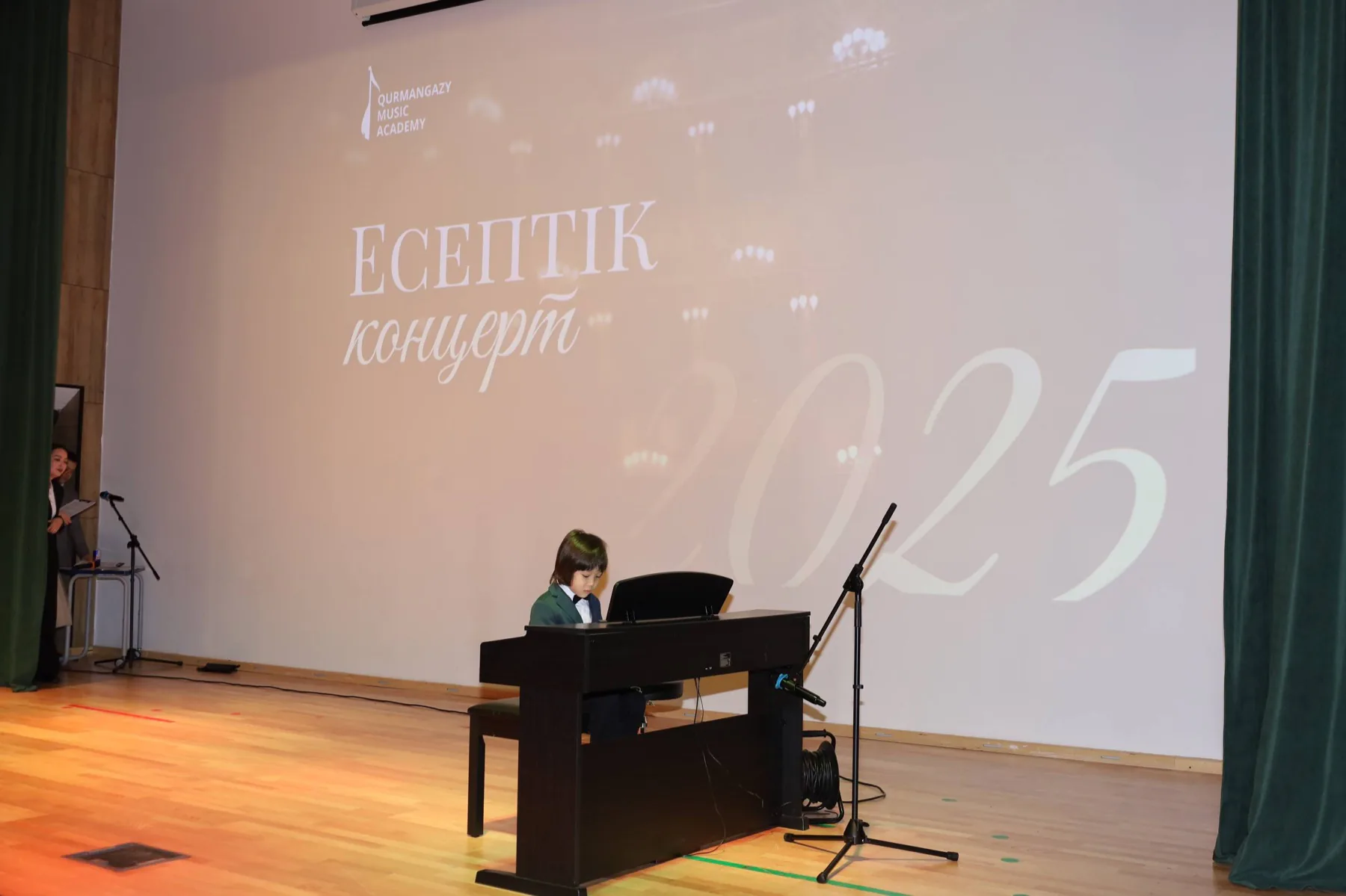 Ученица играет на фортепиано на большой сцене